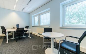 A well-lit office space rental at Joop Geesinkweg 901-999, Amsterdam Amstel Business Park with a white round table and comfortable chairs.