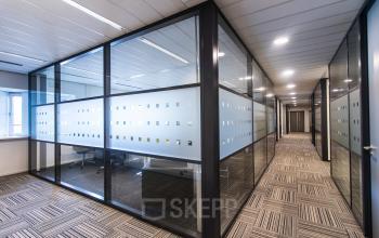 Modern office space rental at Joop Geesinkweg 901-999, Amsterdam Amstel Business Park with glass partitioned meeting area.