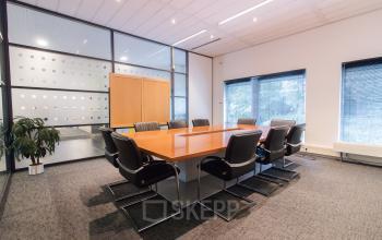 Spacious conference room in Amsterdam Amstel Business Park featuring a large table, chairs, and ample natural light for office space rental.