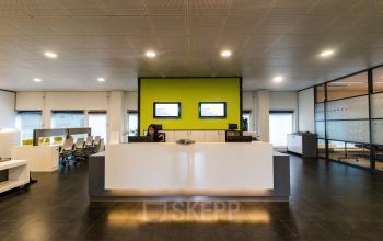 Modern reception area at Joop Geesinkweg 901-999, office space rental in Amsterdam Amstel Business Park, with a welcoming desk and employee.