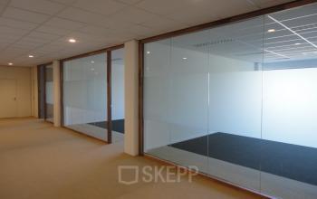 Vacant office space available for rent at Joan Muyskenweg 22 in Amsterdam Amstel Business Park, featuring glass walls and ample room.