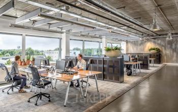 Modern workspace at Joan Muyskenweg 22 in Amsterdam Amstel Business Park featuring open desks, natural light, and people collaborating on business activities.