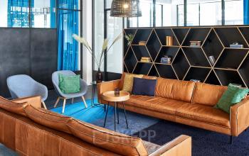 Comfortable lounge area with modern leather sofas and stylish decor at office space rental, Joan Muyskenweg 22, Amsterdam Amstel Business Park.