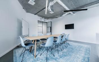 Modern conference room with a long table and sleek chairs located at H.J.E. Wenckebachweg 90-108, in Amsterdam Amstel Business Park, available for office space rental.