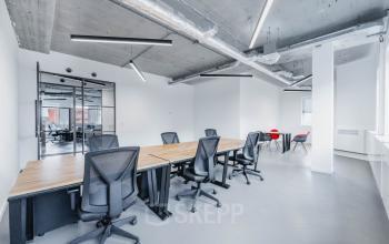 Modern office space at H.J.E. Wenckebachweg 90-108, Amsterdam Amstel Business Park, featuring large desks, ergonomic chairs, and industrial touches. Ideal for office space rental.