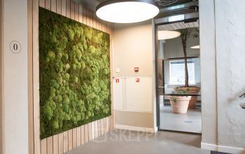 Interior view at H.J.E. Wenckebachweg 90-108, Amsterdam Amstel Business Park, featuring a modern office space with a green plant wall and stylish decor. Ideal for office space rental.