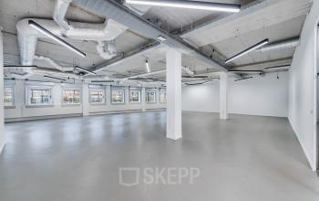 Spacious, modern office space rental at H.J.E. Wenckebachweg 90-108 in Amsterdam Amstel Business Park with wide windows and exposed ceilings.