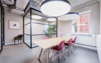 Modern office space at H.J.E. Wenckebachweg 90-108 in Amsterdam Amstel Business Park, featuring a large table with chairs, ample natural light, and contemporary design elements.