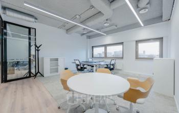 Modern office space with large windows, tables, chairs, storage cabinets, and natural light at Joop Geesinkweg 601, Amsterdam Amstel Business Park.