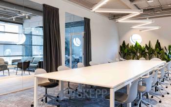 Modern conference room at Joop Geesinkweg 601, Amsterdam Amstel Business Park, furnished with a large table and chairs with contemporary lighting.