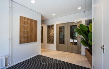 Entrance area at Joop Geesinkweg 501 in Amsterdam Amstel Business Park with clean design, potted plant, and floor directory.