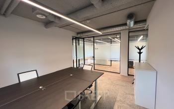 Modern furnished office space at Joop Geesinkweg 601, Amsterdam Amstel Business Park, featuring desks, chairs, and glass partition walls.