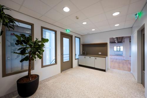 Modern office interior at Joop Geesinkweg 601, Amsterdam Amstel Business Park, featuring a small kitchenette and potted plant.