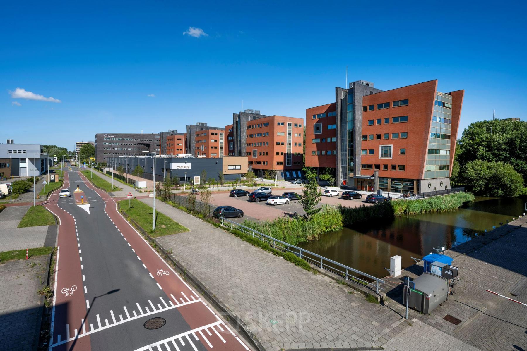 View of office buildings at Joop Geesinkweg 601, Amsterdam Amstel Business Park, featuring modern architecture and spacious parking area.