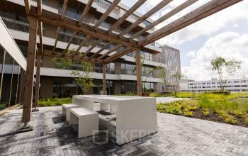 Outdoor communal area at Willem Fenengastraat 16, Amsterdam Amstel, suitable for rent office space with modern seating under a wooden pergola. Office space rental available nearby.