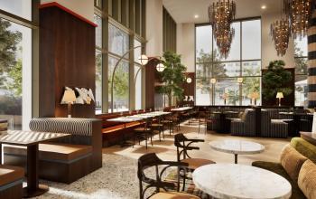 Modern office space with high ceilings, large windows, and stylish seating at Willem Fenengastraat 16, Amsterdam Amstel, perfect for rent. The design combines comfort with contemporary decor, enhancing productivity.