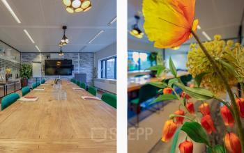 Spacious and well-lit conference room at Prins Bernhardplein 200, Amsterdam Amstel, perfect for rent office space, featuring a large wooden table surrounded by comfortable chairs and modern decor.