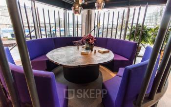 Furnished office space for rent at Prins Bernhardplein 200, Amsterdam Amstel features a round table with vibrant purple seating, ideal for informal meetings or collaborative work.