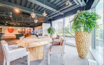 Modern furnished office space at Prins Bernhardplein 200, Amsterdam Amstel with unique wooden table and large windows. Perfect for office space rental.