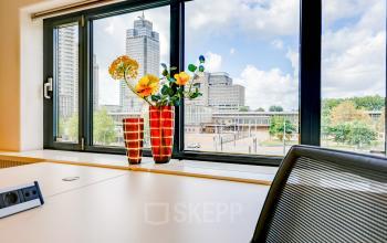Bright office space at Prins Bernhardplein 200, Amsterdam Amstel, featuring a desk with chairs and a view of the cityscape.