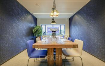 Modern conference room with wooden table and upholstered chairs, available for office space rental at Prins Bernhardplein 200, Amsterdam Amstel.
