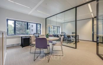 Modern office space at Prins Bernhardplein 200 in Amsterdam Amstel, featuring glass walls, desks, and seating. Ideal for office space rental with natural light.