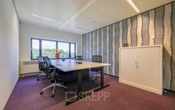 Furnished office space for rent at Prins Bernhardplein 200, Amsterdam Amstel, featuring a table, chairs, and a view of the outdoors.