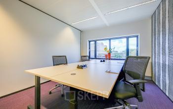 Bright office space with desks and chairs, featuring a window view at Prins Bernhardplein 200, Amsterdam Amstel. Ideal for office space rental.