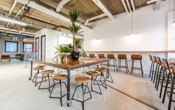 Modern office space rental at Wibautstraat 135, Amsterdam Amstel, featuring a long communal table and chic industrial design.