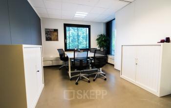 Modern, well-lit office space rental at De Cuserstraat 93 in Amsterdam Buitenveldert with a round meeting table and chairs.