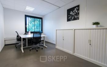Well-lit, tidy office space rental available at De Cuserstraat 93, Amsterdam Buitenveldert, with modern furniture and artwork on the walls.