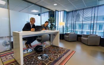 Amsterdam Buitenveldert office space rental at De Cuserstraat 93 with professionals engaged in a consultation.