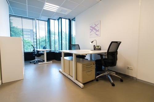 Modern office space rental at De Cuserstraat 93, Amsterdam Buitenveldert, with well-lit desks and ergonomic chairs.