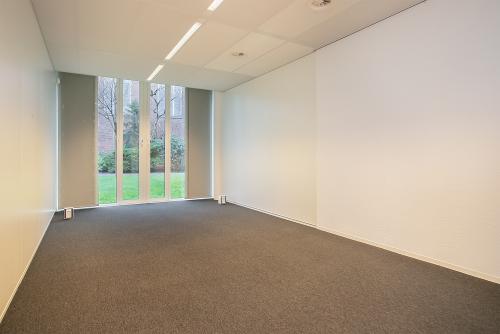 Spacious empty office interior with large windows at De Cuserstraat 91, ideal for office space rental in Amsterdam Buitenveldert.