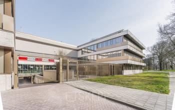 Exterior view of office space for rent at Walborg 2A, Amsterdam Buitenveldert, featuring a modern building with greenery.