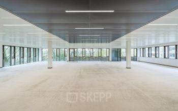 Spacious, unfurnished office available for rental at Walborg 2A, Amsterdam Buitenveldert, featuring large windows that provide ample natural light.