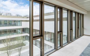 Spacious interior view of office space at Walborg 2A, Amsterdam Buitenveldert, ideal for office space rental with expansive windows overlooking the courtyard. Rent office space with ample natural light.