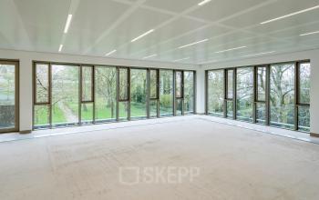 Spacious office area with large windows overlooking a green landscape at Walborg 2A, perfect for those seeking office space rental in Amsterdam Buitenveldert.