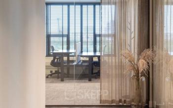 Modern office space for rent at Walborg 2A, Amsterdam Buitenveldert, featuring sleek furnishings and large windows with blinds.
