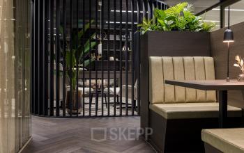 Furnished office space at Walborg 2A, Amsterdam Buitenveldert, featuring sleek seating and lush greenery, ideal for rent office space seekers.