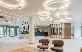 Modern office space for rent at Walborg 2A, Amsterdam Buitenveldert, featuring stylish lighting and comfortable seating in a spacious interior.