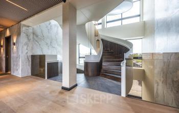 Interior view of Zwaansvliet 1 in Amsterdam Buitenveldert, featuring a stylishly designed spiral staircase in a modern office space.