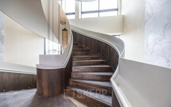 Modern staircase in an Amsterdam Buitenveldert office, showcasing elegant wooden steps and sleek design elements, available for office space rental.