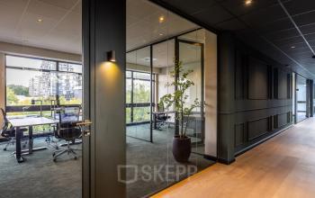 Modern office space at Zwaansvliet 1, Amsterdam Buitenveldert with large windows and glass partitions providing a bright and open atmosphere, ideal for office space rental.
