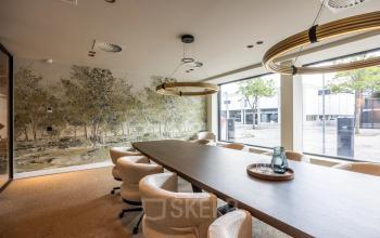 Conference room at Zwaansvliet 1, Amsterdam Buitenveldert, featuring a long table, modern lighting, and large windows. Ideal for office space rental.