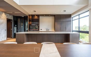 Furnished office space available for rent at Zwaansvliet 1 in Amsterdam Buitenveldert, featuring a modern interior with wooden finishes and ample natural light through large windows.