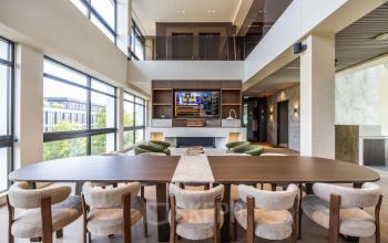 Modern, furnished office space for rent at Zwaansvliet 1, Amsterdam Buitenveldert, featuring a spacious conference room with large windows and a stylish table surrounded by comfortable chairs.