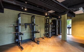 A furnished exercise area perfect for office space rental at Zwaansvliet 1, Amsterdam Buitenveldert, featuring fitness equipment and wood flooring.