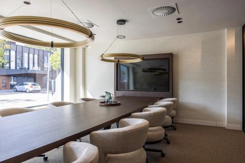 Modern conference room with a long wooden table and comfortable chairs near a large window in Zwaansvliet 1, Amsterdam Buitenveldert, ideal for office space rental.