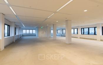 Spacious, unfurnished office to rent at Buitenveldertselaan 102-120, Amsterdam Buitenveldert, featuring large windows and ample natural light.